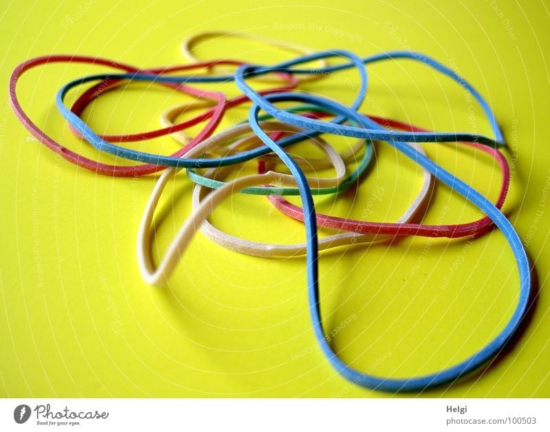 many colourful rubber bands on yellow background Rubber Muddled Accumulation Elastic Distend Attachment Multiple Multilateral Heap Together Red Green White