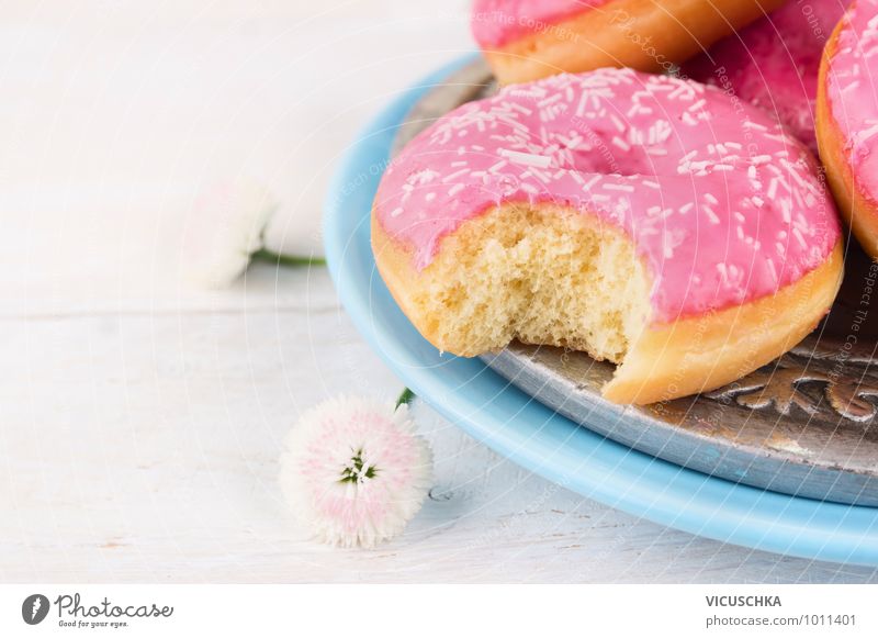 Pink cast off donut on blue plate Food Cake Nutrition Breakfast Buffet Brunch Plate Style Design Blue Turquoise White Background picture Donut Flower Bite