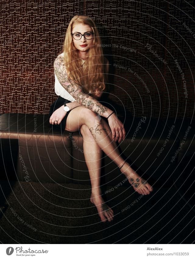 don't wait long Sofa Wallpaper Night life Young woman Youth (Young adults) Face Legs 18 - 30 years Adults T-shirt Skirt Tattooed Eyeglasses Barefoot Red-haired
