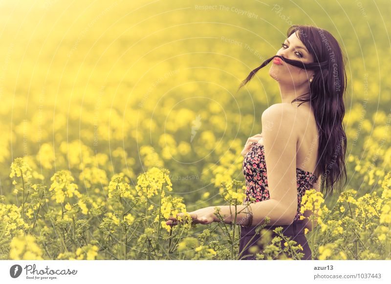 Funny beautiful spring girl with hair mustache in yellow meadow. Attractive happy young girl enjoying warm summer sun and health in wide green and yellow meadow. Part of a series.