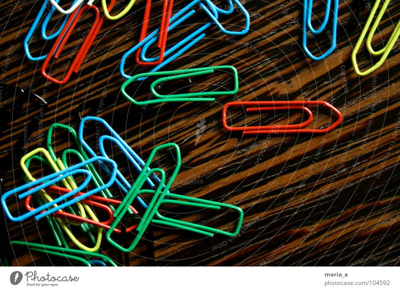 chaos of clamps Paper clip Chaos Muddled Multicoloured Wood Yellow White Reddish black Green Flexible Wire Attachment paperclip chaos Wood grain