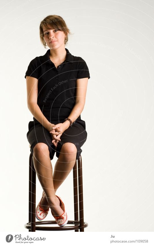 Seat Bar Stool Woman Isolated Image Full-length Portrait photograph Serene Calm Contentment Frontal Trust Contrast Chair Wait dark clothes black dresses Sit