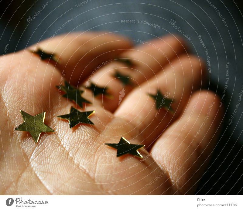 A person holds golden stars in his hand by hand Give Donate Christmas Europe Gift