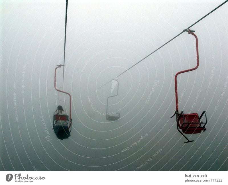 ascent Gray Fog The Assumption Dark Dreary Clouds Bad weather Narrow Exterior shot Woman Red White Chair lift Cable car Winter Autumn Mountain Sky melancholy