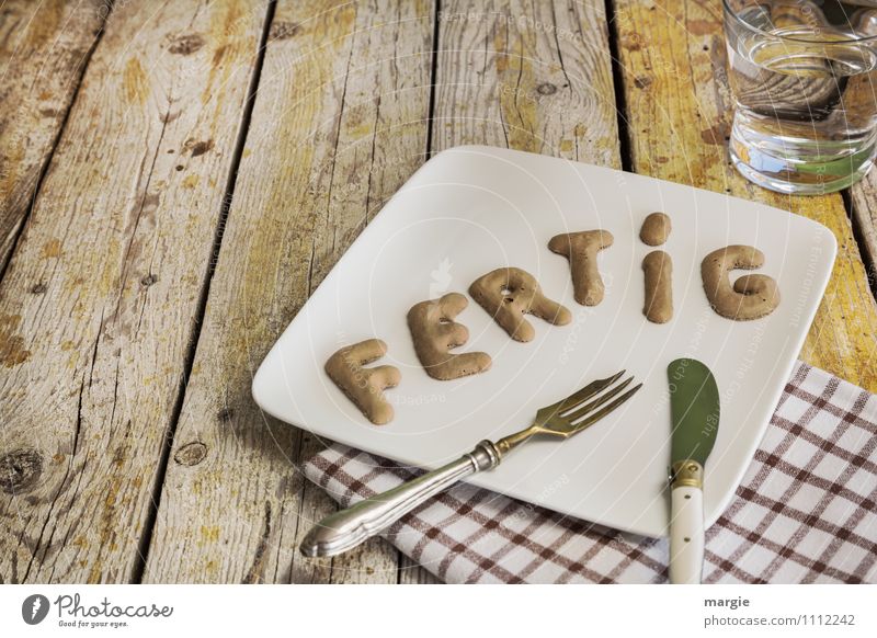 The letters DONE on a plate with a knife and fork, napkin, a glass of water on a rustic wooden table Food Breakfast Lunch Dinner Banquet Picnic Diet Fasting