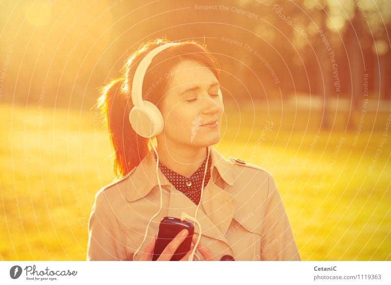 Woman listening to music in sunlight. Lifestyle Joy MP3 player Feminine Young woman Youth (Young adults) Adults 18 - 30 years Nature Park Happiness