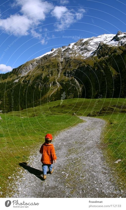 on the way Switzerland Child Small Heavenly Clouds Meadow Grass Swing In transit Hiking To go for a walk Boy (child) Baseball cap Idyll Beautiful Pleasant