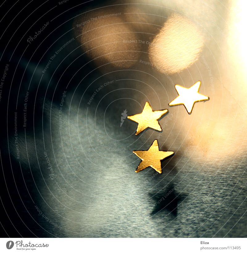 Three golden stars on a blurred background with lights and beautiful bokeh; Christmas, Advent already Christmas decoration Playing Winter Decoration Twelfth Day