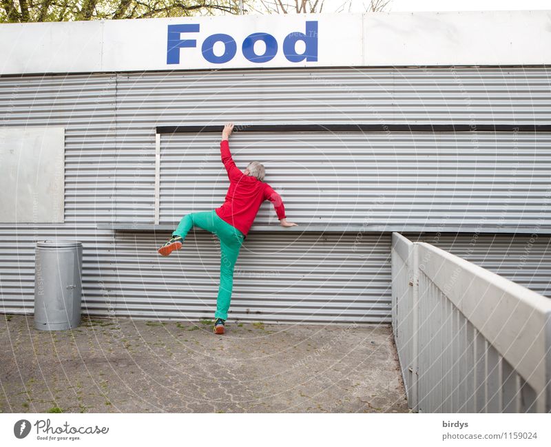 Man in colorful outfit mounts a fast food restaurant with the inscription " FOOD ". Nutrition Young man Appetite Adults 1 Human being 30 - 45 years