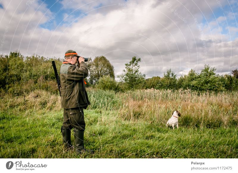 Hunter with binculars Relaxation Leisure and hobbies Hunting Sports Human being Man Adults Nature Landscape Autumn Jacket Hat Dog Binoculars Observe Stand Wild