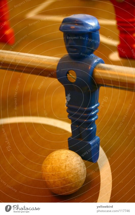 The captain. Table soccer Soccer player Sports Playing Ball Sphere Blue Piece Screw Center circle Front view Close-up Rod Perspective Shallow depth of field