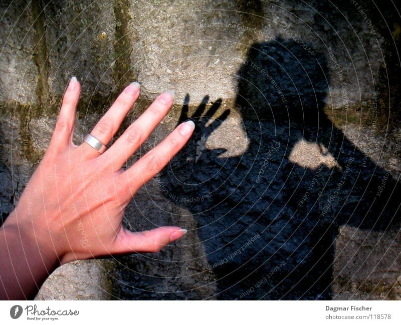Who's afraid of the black man? Colour photo Light Shadow Hand Fingers Wall (barrier) Wall (building) Stone Threat Dark Creepy Gray Black Protection Concern Fear