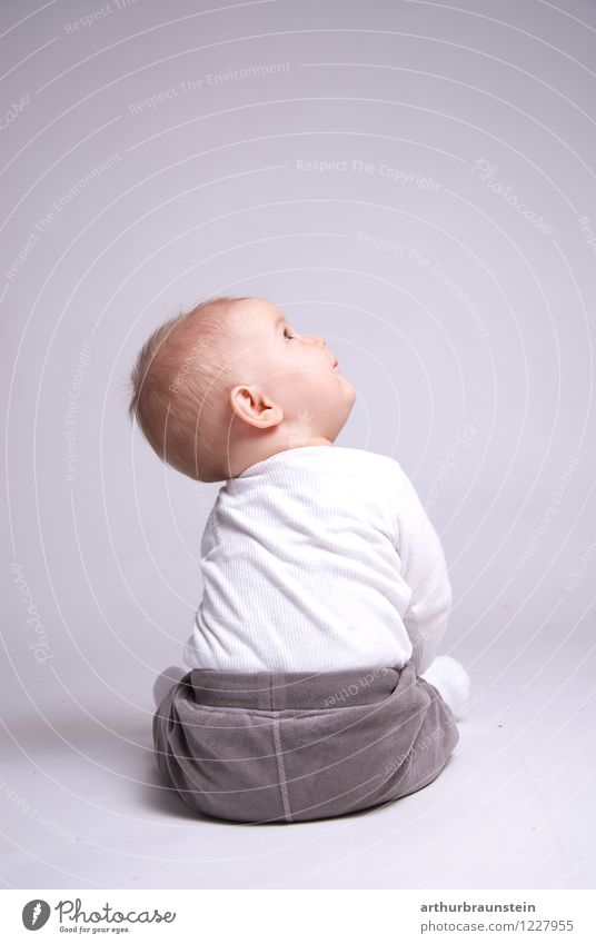 Baby sitting on white floor in photo studio against white background and looking upwards Happy Parenting Kindergarten Human being Masculine Child Toddler
