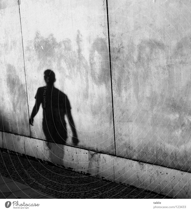 single Light Evening sun Man Concrete Wall (barrier) Wall (building) Gray Town House (Residential Structure) Upper body Sidewalk Shadowy existence Shadow play