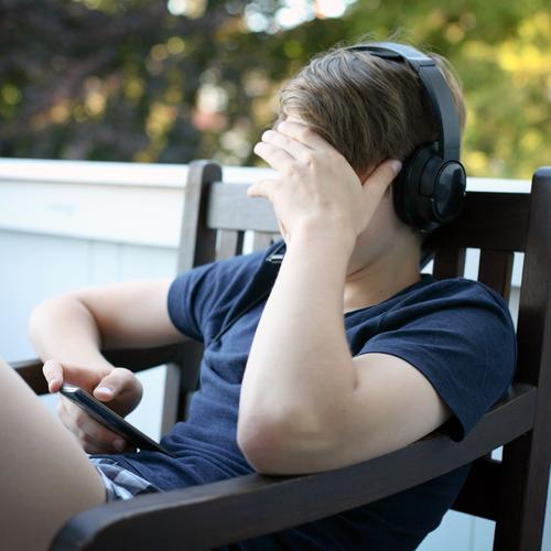 Boy with headphones and mobile Lifestyle Leisure and hobbies Computer games To talk Entertainment electronics Cellphone Headset MP3 player PDA Headphones