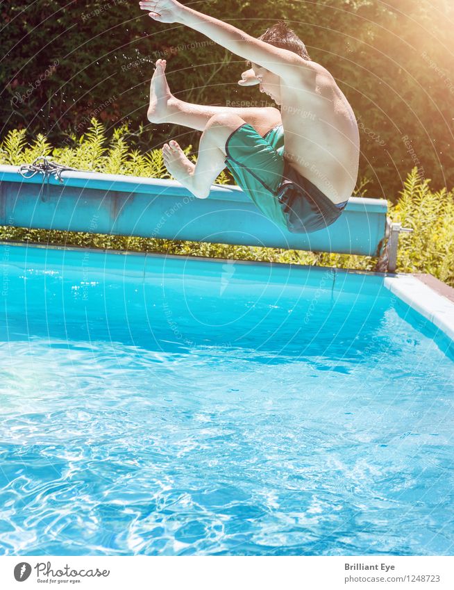 Boy jumps into the water Lifestyle Summer Sun Swimming pool Child Boy (child) Water Sunlight Flying Sports Jump Esthetic Athletic Authentic Wet Positive Blue
