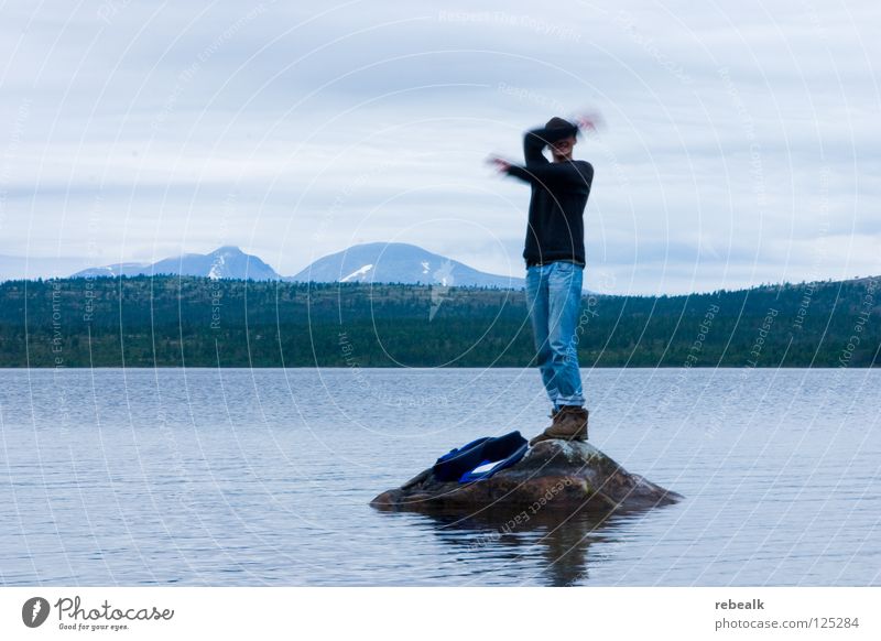 Suspended Exterior shot Adventure Island Waves Mountain Man Adults Arm Hand Nature Water Sky Clouds Rock Lake Jeans Sweater Threat Blue Gray Grief Loneliness
