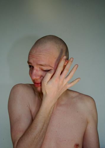 Young man is sad and cries because he is sensitive and bald and he is naked and defenseless Authentic Life Really Portrait photograph Gesture Heartrending