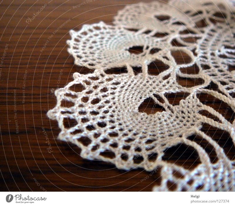 Close-up of a crocheted lace doily on a table Blanket Craft (trade) Effort Sewing thread Table Flat Round Warped Leisure and hobbies White Brown