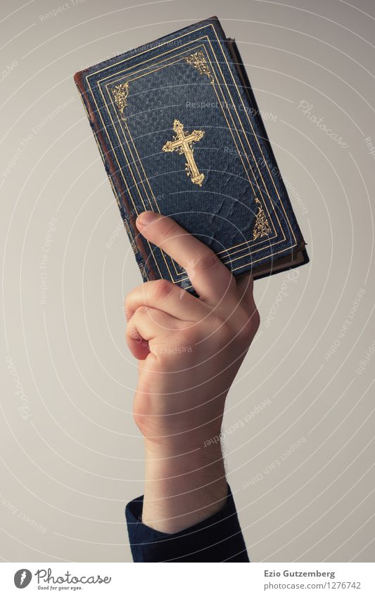 A hand that holds a Bible in the air Beautiful Profession Human being Masculine Hand Fingers Book Reading Shirt Paper To hold on Esthetic Bright Retro