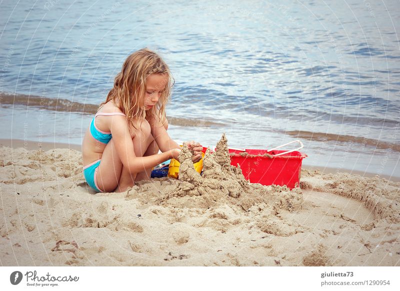 Building sandcastles by the sea Leisure and hobbies Playing Children's game Sandcastle Vacation & Travel Summer Summer vacation Beach Ocean Human being Feminine