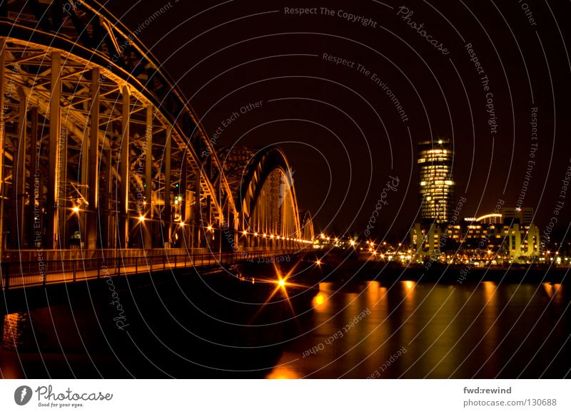 Cologne in a different way Light Night Town Long exposure Night shot Yellow High-rise Steel Railroad Bridge triangletower Skyline Gold Rhine Water Reflection