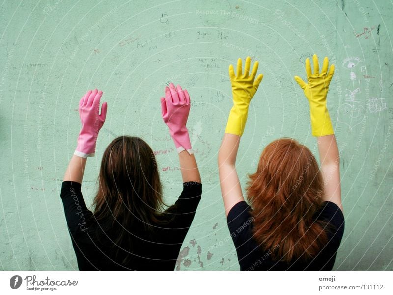 Two unidentified women wearing gloves Gloves Rubber Pink Yellow Gaudy Intoxicant Turquoise Wall (building) Hand Describe Dirty Cleaning Noble Whimsical Strange