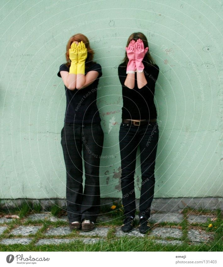 two women hiding behind rubber gloves Gloves Rubber Pink Yellow Gaudy Intoxicant Turquoise Wall (building) Hand Describe Dirty Cleaning Noble Whimsical Strange