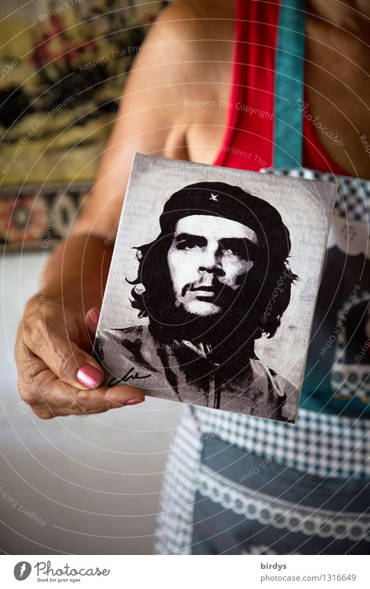 A Cuban woman holds a photo of Che Guevara in the camera che guevara Vacation & Travel Past Young man Female senior Revolution Woman Human being
