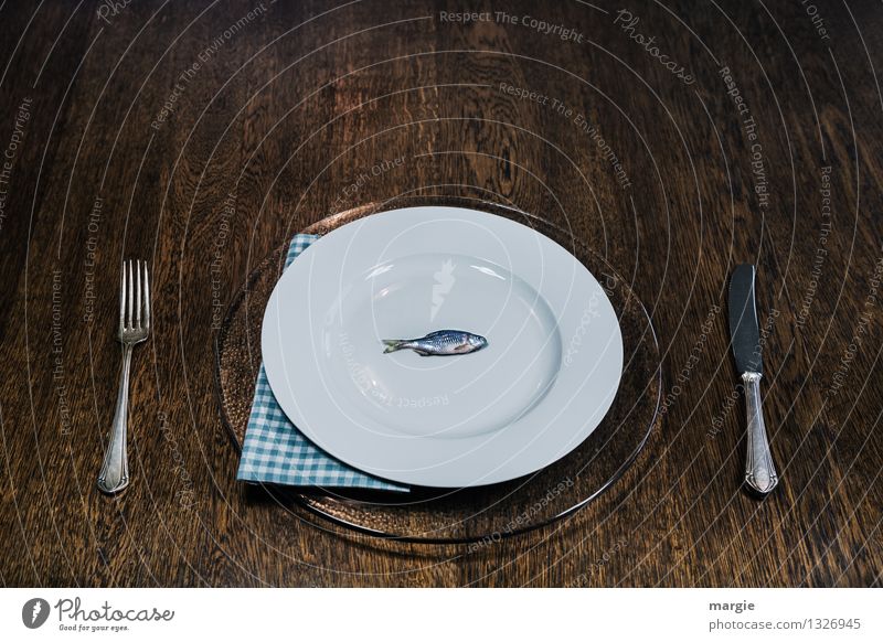 Fish is healthy: a small fish on a large plate with knife and fork and napkin Food Nutrition Lunch Dinner Buffet Brunch Banquet Business lunch Organic produce