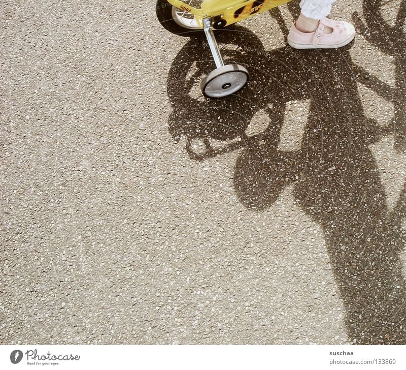99 .. Asphalt Child Toddler Girl Small Yellow Driving Traffic infrastructure Joy Street bicycle support wheels Feet Exterior shot