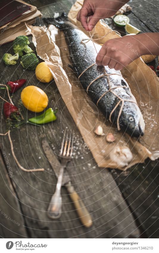 Tying a rope on fish for grilling Seafood Vegetable Dinner Table Cook Rope Hand Paper Dark Fresh Delicious Black Cooking Raw Ingredients Meal Lemon Preparation