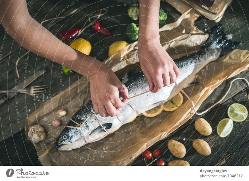 Tying a rope on fish for grilling Seafood Vegetable Dinner Table Cook Rope Hand Paper Dark Fresh Delicious Black Cooking Raw Ingredients Meal Lemon Preparation