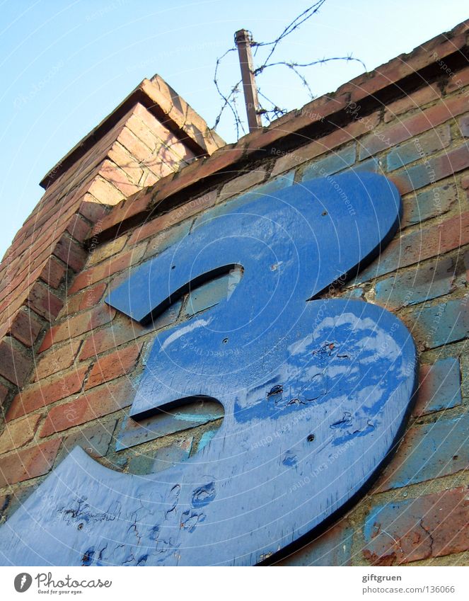 3 Digits and numbers Inscription Lettering Wall (barrier) Barbed wire Barrier Confine Exclude Tower Brick Typography Tin Safety Dangerous Stone Sky