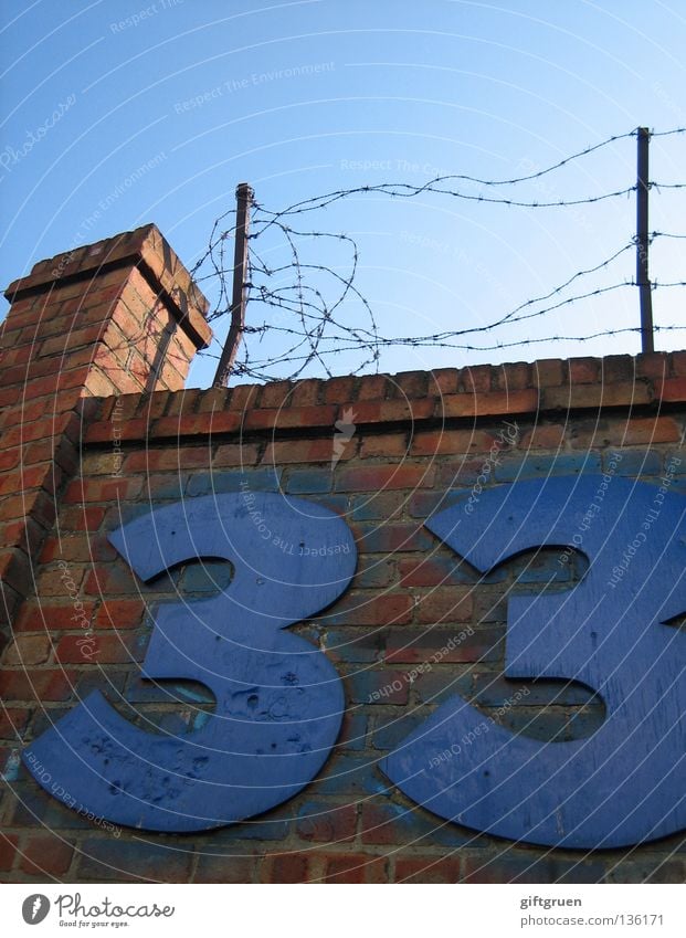 33 Digits and numbers Inscription Lettering Wall (barrier) Barbed wire Barrier Confine Exclude Tower Brick Typography Tin Detail Signage Stone Sky