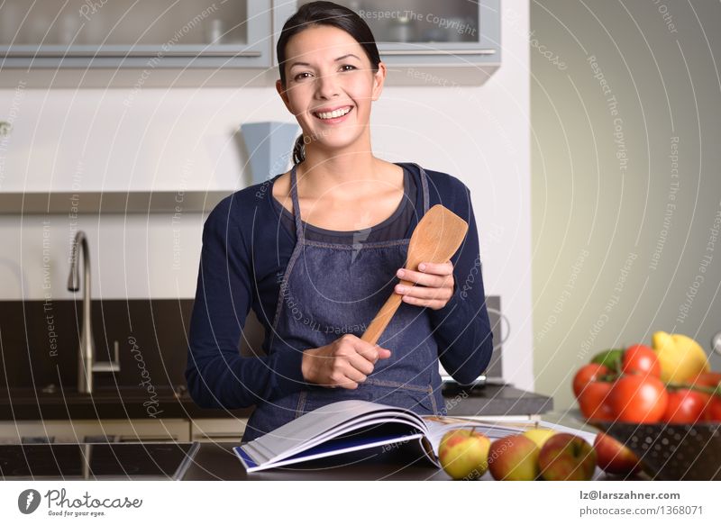 Woman Holding Ladle While Reading a cookbook Vegetable Fruit Nutrition Bowl Happy Face Kitchen Gastronomy Adults 1 Human being 30 - 45 years Book Think Smiling