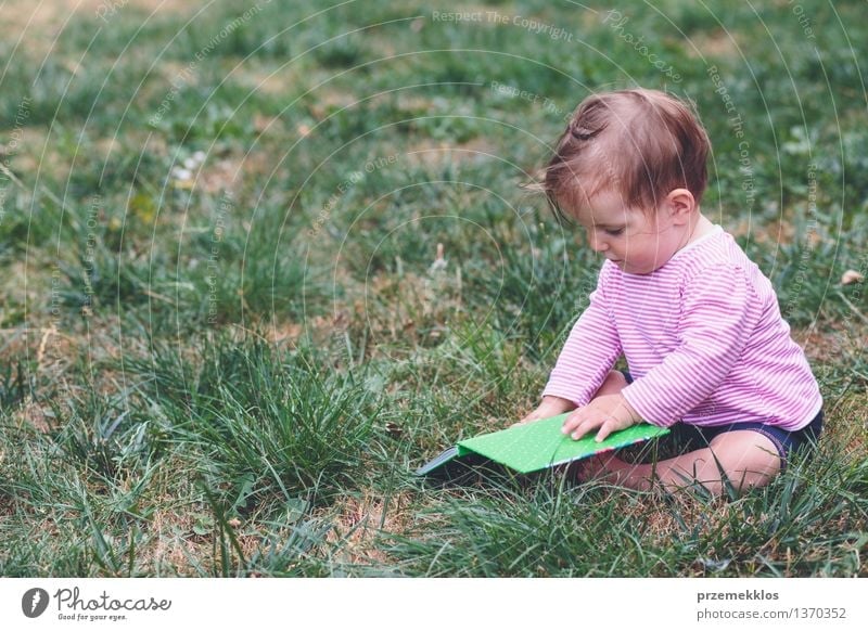 Little baby girl watching a book with pictures Lifestyle Joy Happy Beautiful Playing Child Human being Baby Toddler Girl Infancy 1 0 - 12 months Book Grass