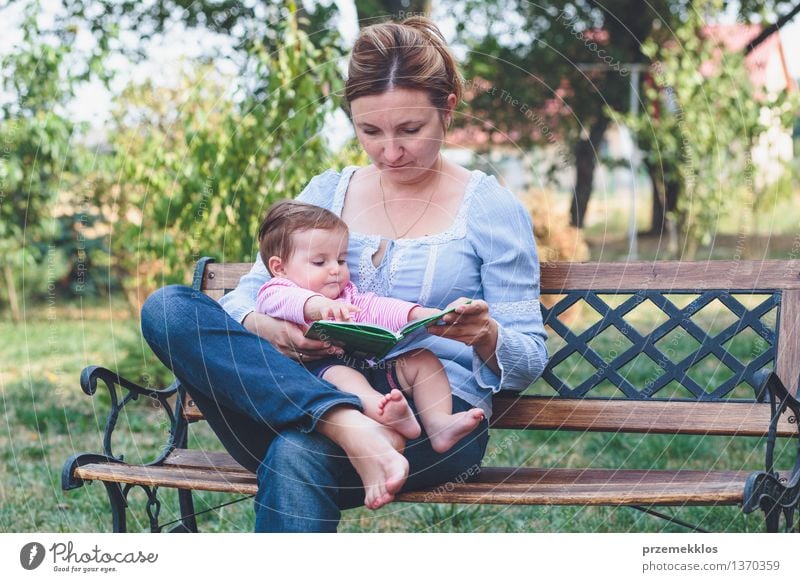 Mom reading a book her little daughter Lifestyle Joy Happy Beautiful Reading Garden Child Baby Toddler Girl Woman Adults Parents Mother Family & Relations