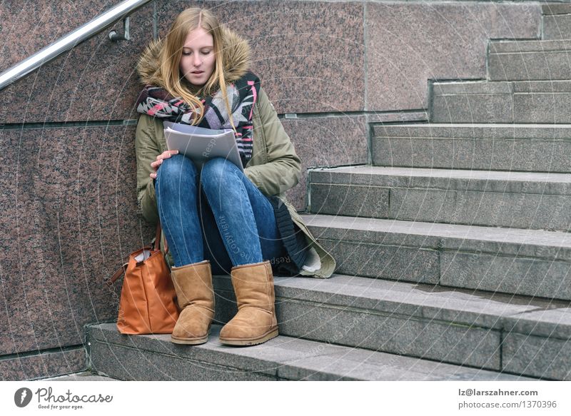 Young woman sitting reading on urban steps Lifestyle Relaxation Reading Winter School Study Academic studies Girl Woman Adults 1 Human being 13 - 18 years