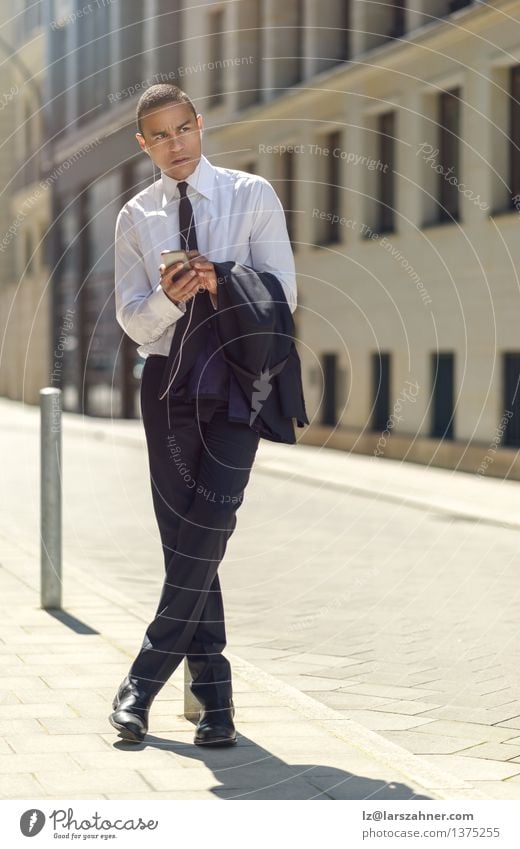Businessman sitting on a bollard reading an sms Reading Summer Financial Industry Telephone PDA Technology Man Adults Suit Tie Sit Modern Smart Self-confident