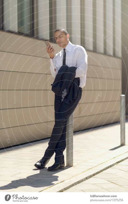 Businessman sitting on a bollard reading an sms Reading Summer Financial Industry Telephone PDA Technology Man Adults Suit Tie Sit Modern Smart Self-confident