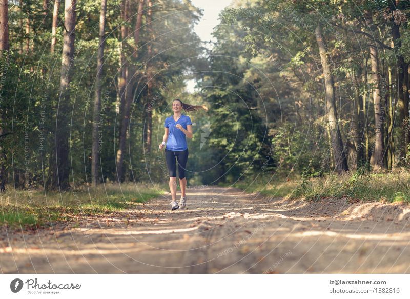 Athletic woman out jogging in a forest Lifestyle Body Sports Jogging Girl Woman Adults 1 Human being 18 - 30 years Youth (Young adults) Nature Landscape Sand