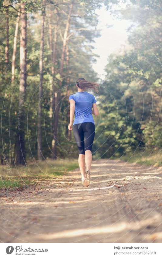 Athletic young woman jogging along a forest track Lifestyle Body Summer Sports Jogging Girl Woman Adults 1 Human being 18 - 30 years Youth (Young adults) Nature