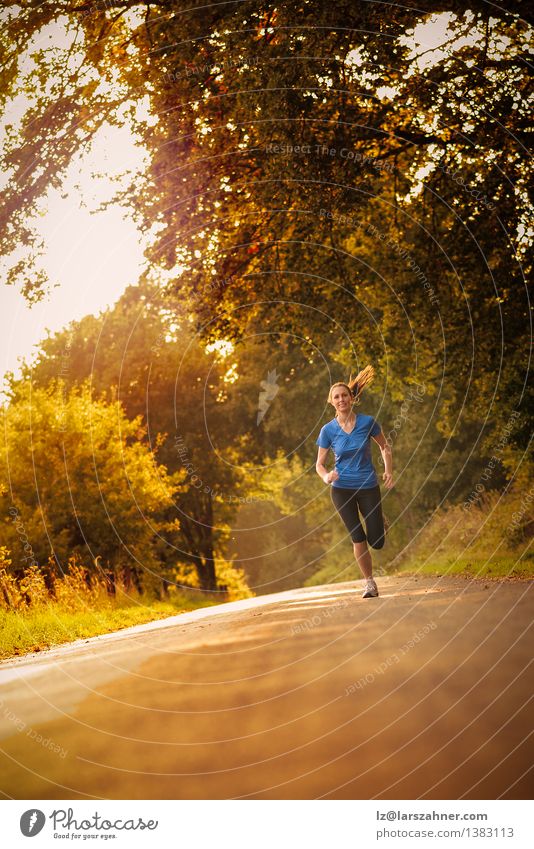 Sporty woman running on a country road Happy Sports Jogging Woman Adults 1 Human being 13 - 18 years Youth (Young adults) Landscape Autumn Tree Leaf Park Street