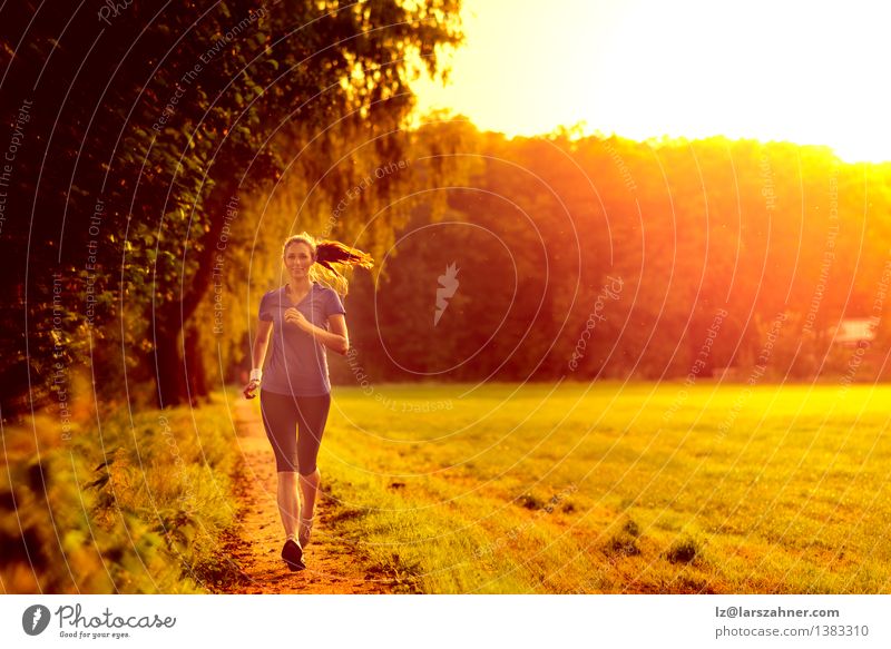 Young woman jogging along a country track Lifestyle Face Summer Sports Jogging Woman Adults Grass Leaf Lanes & trails Fitness Green Determination Loneliness