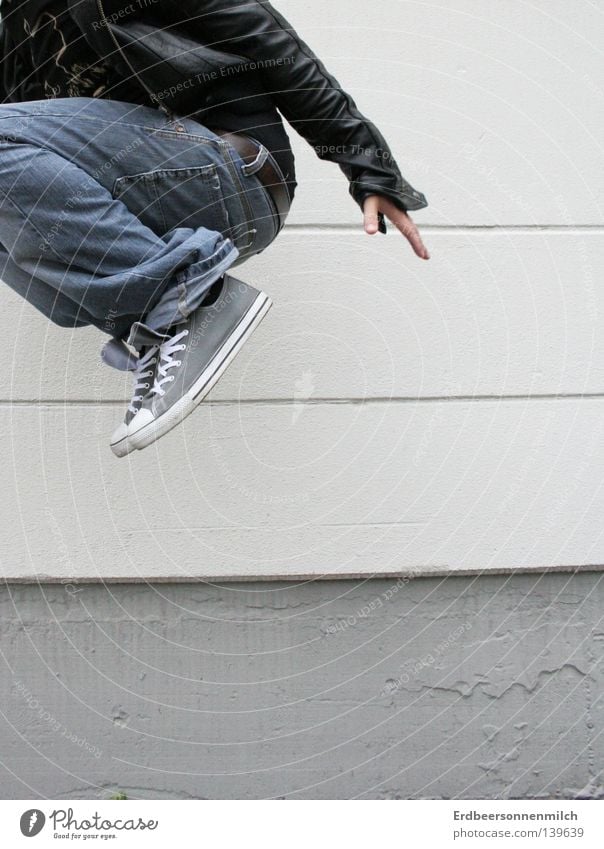 Where are you going? Jump Gray Chucks Wall (building) Man Leather jacket Distress Joy Media Guy Industrial Photography happy Life Jeans Fear Partially visible