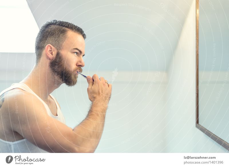 Young bearded man brushing his teeth Face Health care Mirror Bathroom Man Adults Teeth Beard Toothbrush Modern Clean caries cleaning cleanliness Dental
