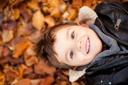 Happy Day Human being Child Toddler Boy (child) Infancy Head 1 3 - 8 years Nature Autumn Weather Beautiful weather Leaf Smiling Laughter Lie Leather jacket