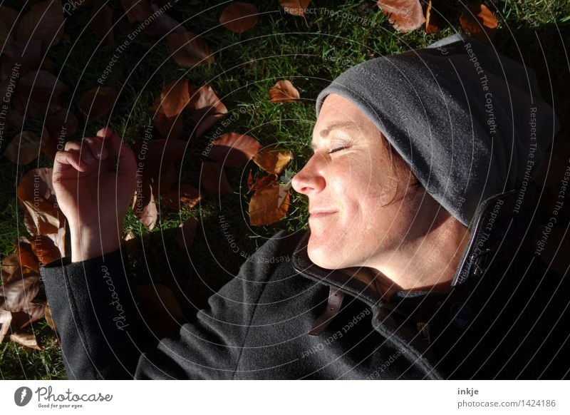 Close-up Smiling woman lying in autumn leaves Lifestyle Harmonious Well-being Contentment Senses Relaxation Calm Leisure and hobbies Woman Adults Face 1