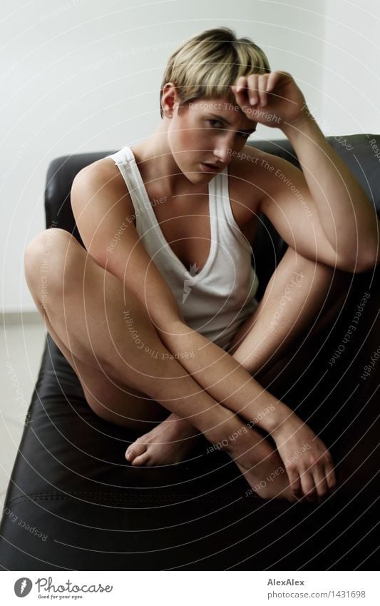 Young athletic slim woman sitting cross legged barefoot in underwear on dark couch Sofa Young woman Youth (Young adults) Face Legs 18 - 30 years Adults